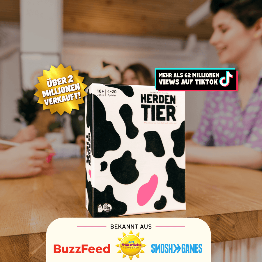 Herdentier Box auf einem Tisch mit Leuten die im Hintergrund spielen. Mit Flashes die aufzählen: über 2 millionen verkauft, mehr als 62 millionen views auf tiktok, bekannt aus buzzfeed, sat 1 Frühstücksfernsehen und smosh games.